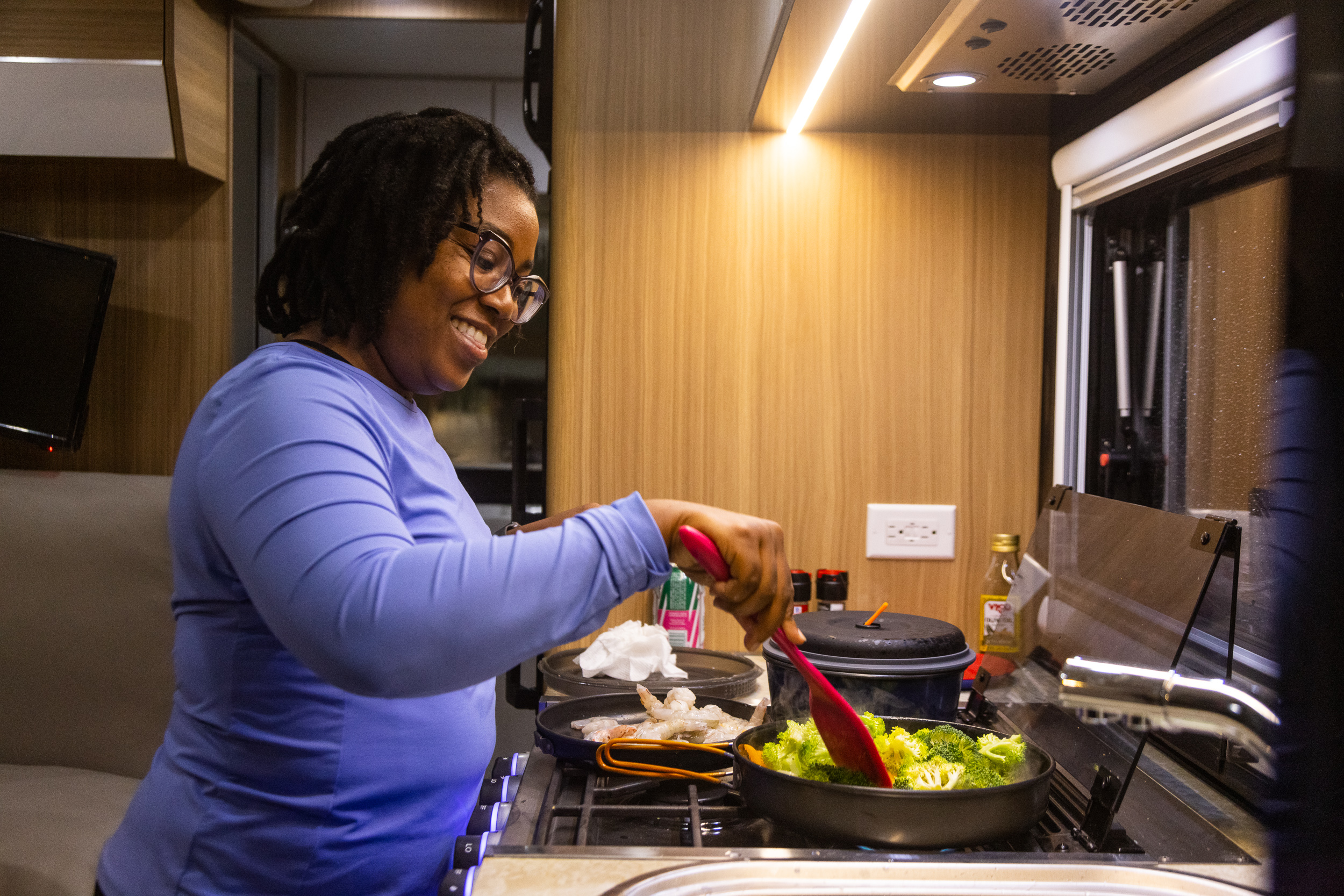 This image has an empty alt attribute; its file name is woman-cooking-in-RV-kitchen.jpg